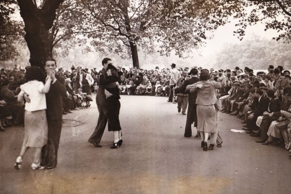 Schwarz-Weiß-Bild aus den 30er Jahren. Drei Paare tanzen auf der Straße vor Publikum.